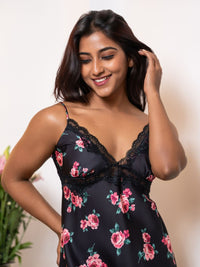 Woman wearing a black floral nightgown with a plain background
