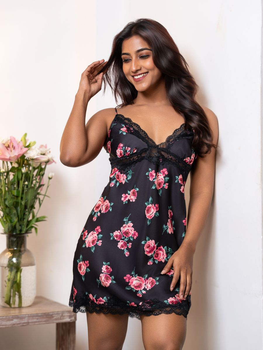 Woman wearing a black floral nightgown with a white background