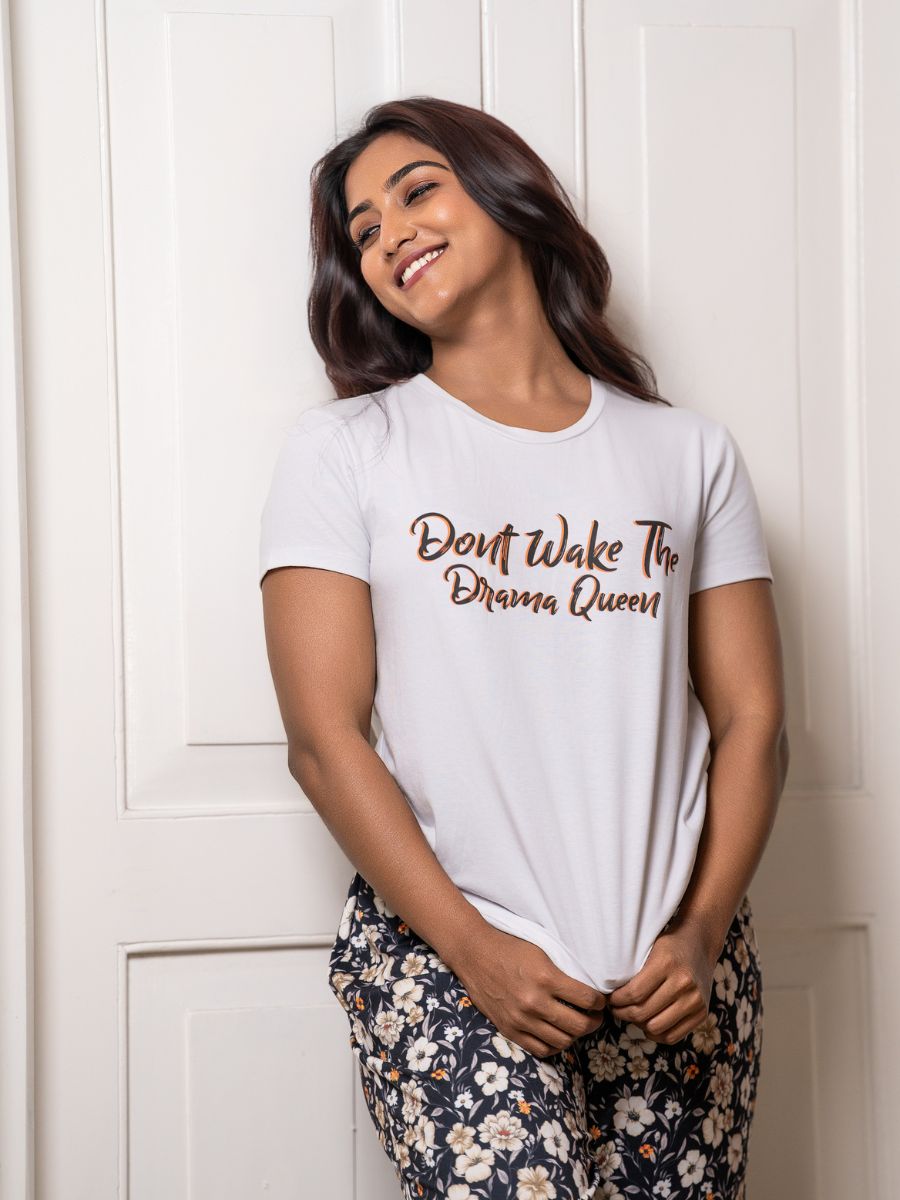 Woman wearing a white t-shirt with 'Don't Wake The Drama Queen' text against a white wooden panel background