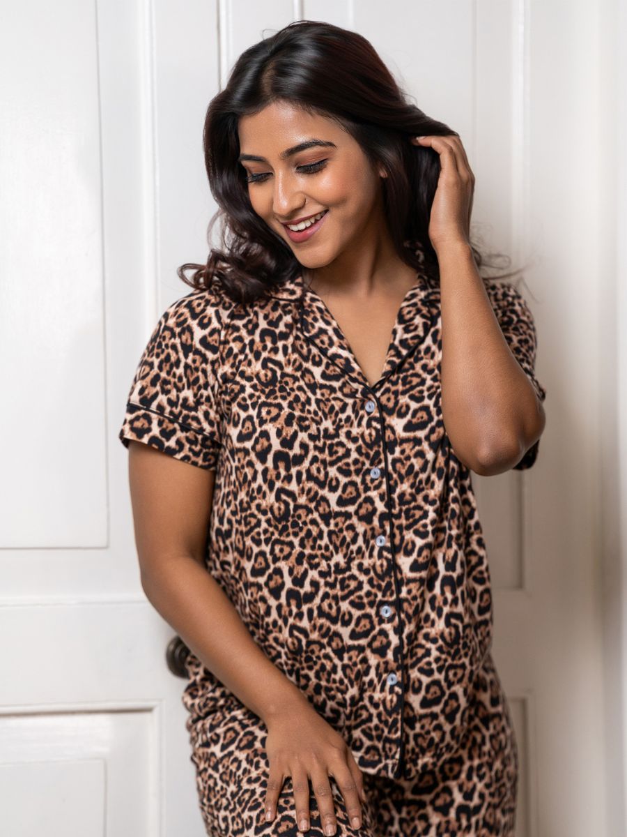 Woman wearing a leopard print outfit standing against a white background
