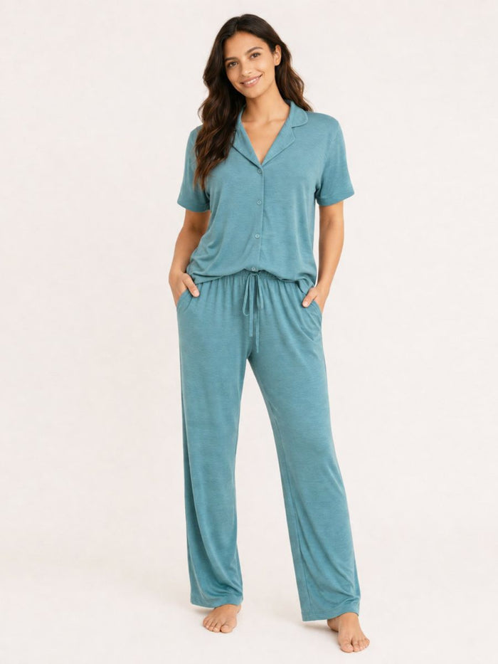Woman wearing a teal pajama set on a white background