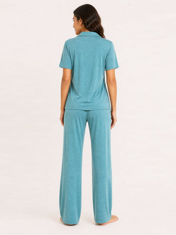 Woman wearing a teal pajama set on a white background