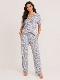 Woman wearing a patterned pajama set on a plain background