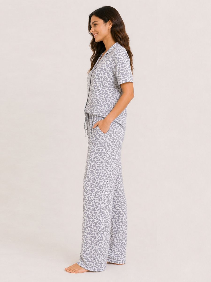 Woman wearing a patterned pajama set on a plain background