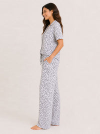 Woman wearing a patterned pajama set on a plain background