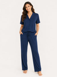 Woman wearing a navy blue pajama set on a white background