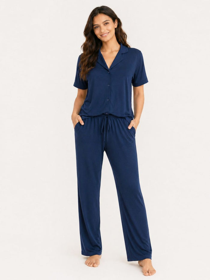Woman wearing a navy blue pajama set on a white background