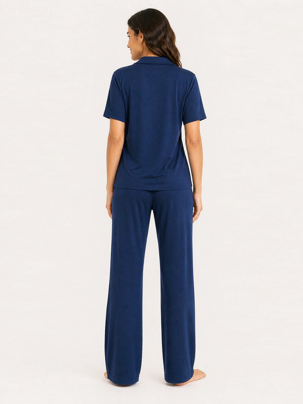 Woman wearing a navy blue pajama set on a white background