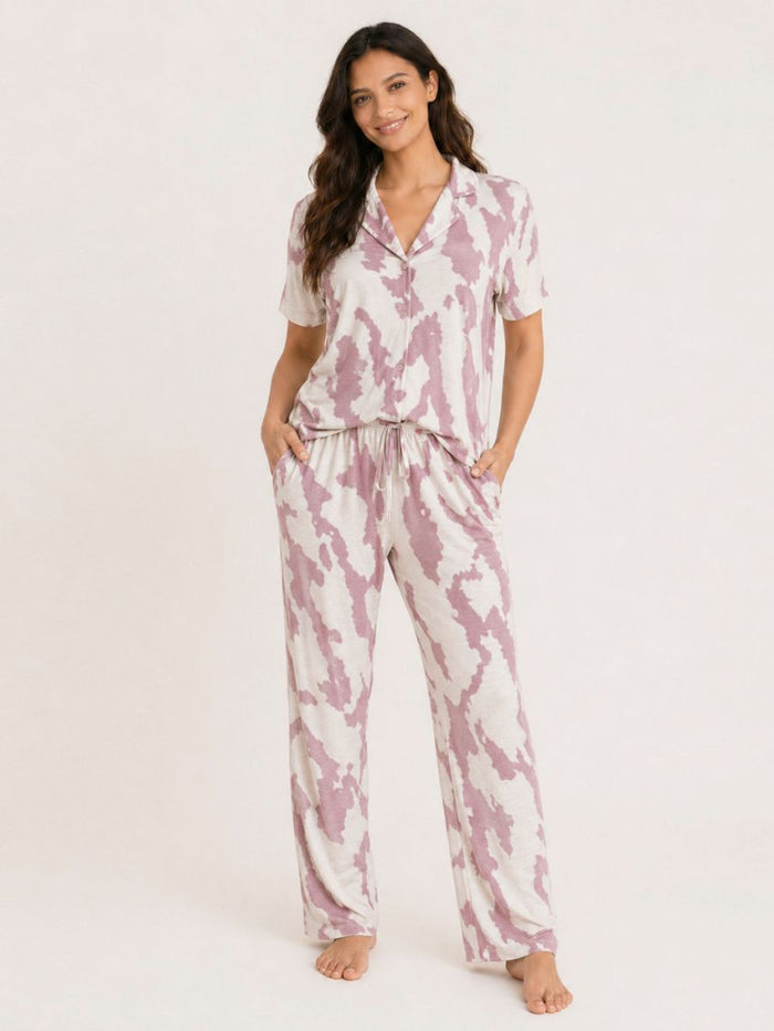 Woman wearing a pink and white tie-dye pajama set on a white background