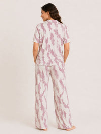 Woman wearing a pink and white tie-dye pajama set on a plain background