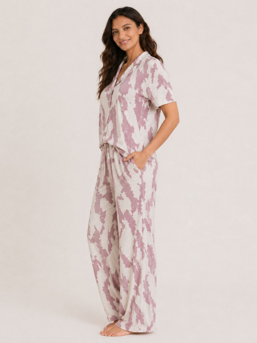 Woman wearing a pink and white tie-dye pajama set on a light gray background