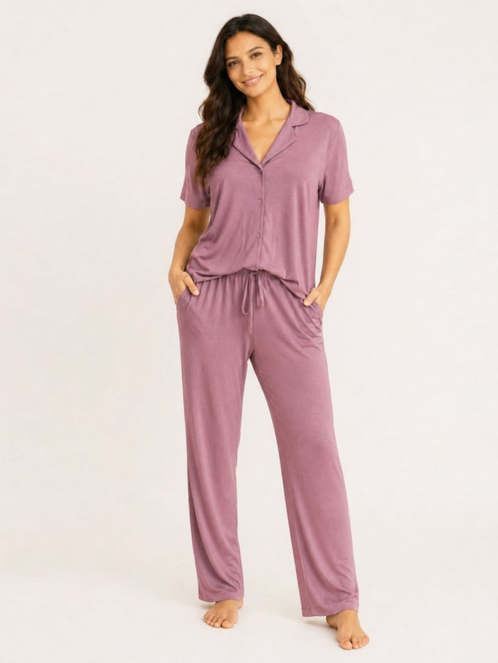Woman wearing a mauve pajama set on a white background