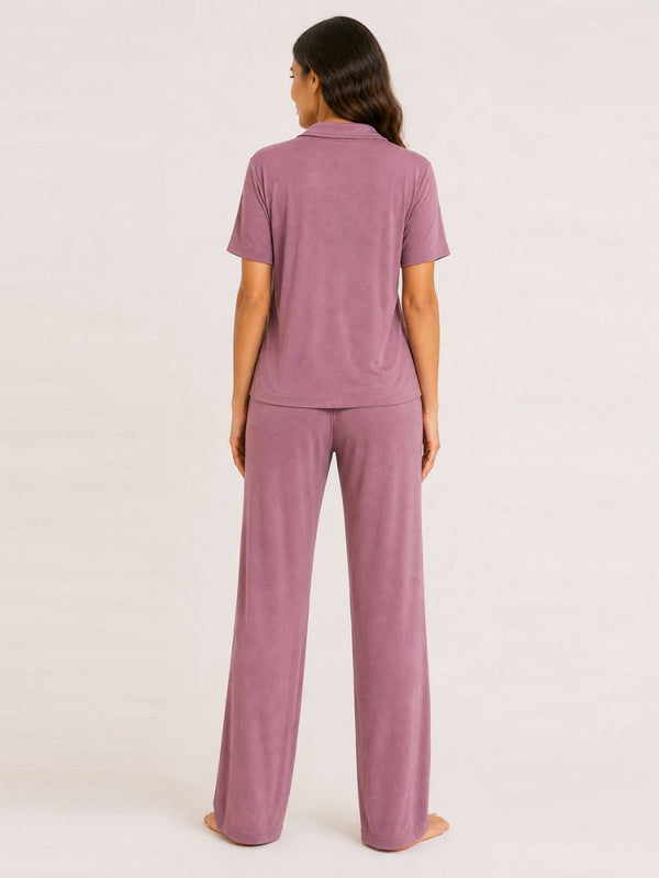 Person wearing a mauve pajama set on a white background