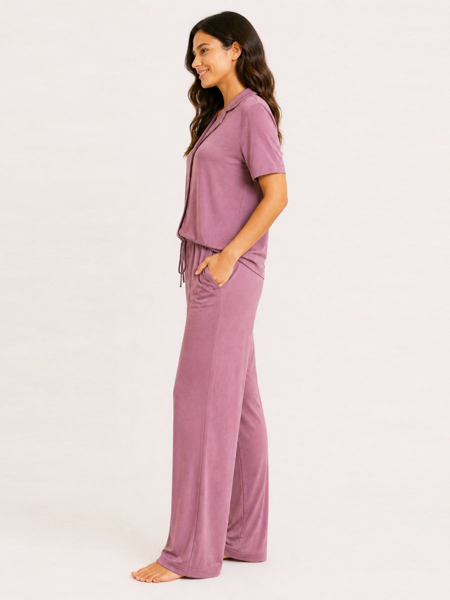 Person wearing a mauve pajama set on a white background
