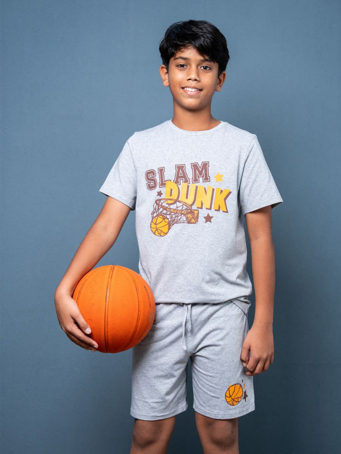 Child wearing a 'Slam Dunk' t-shirt holding a basketball against a blue background