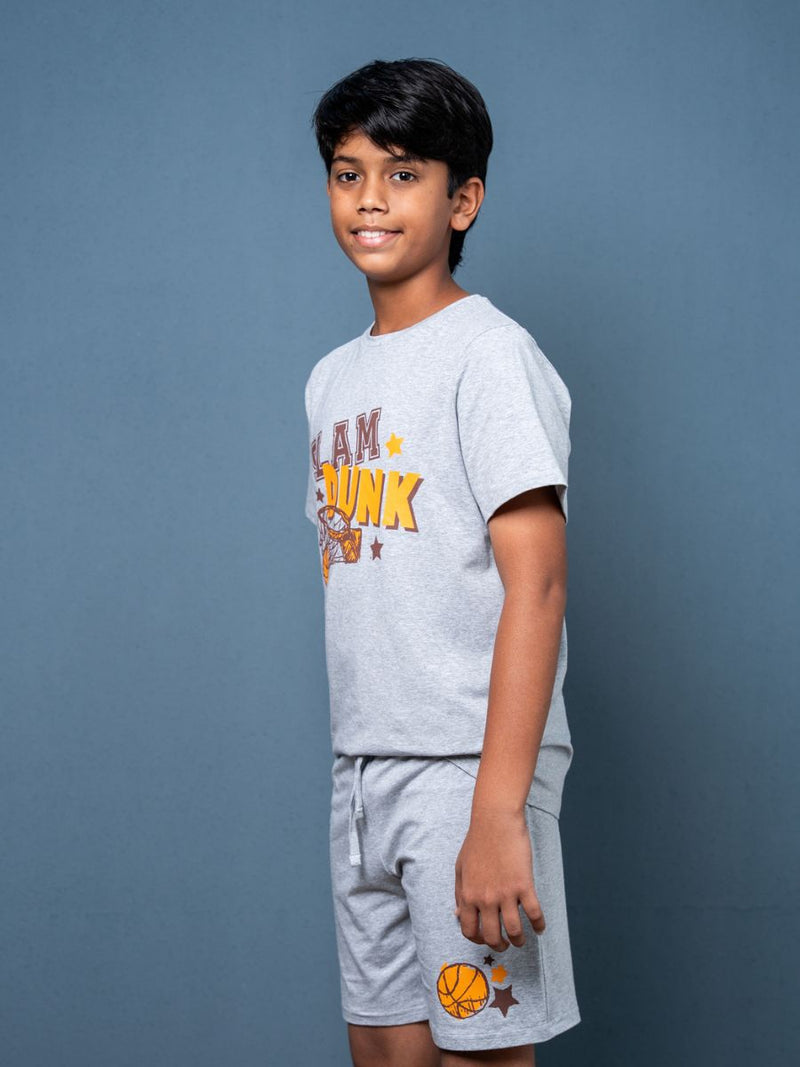Child wearing a gray t-shirt and shorts with text and graphics on a blue background