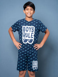 Child wearing a navy blue pajama set with 'Boys Rule' text on a gray background