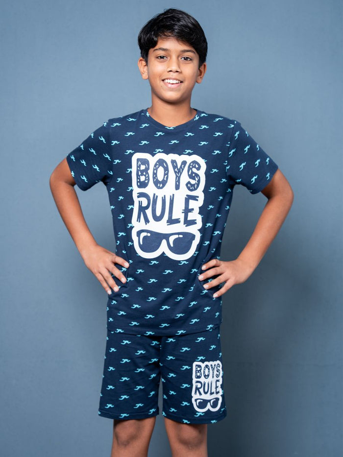 Child wearing a navy blue pajama set with 'Boys Rule' text on a gray background