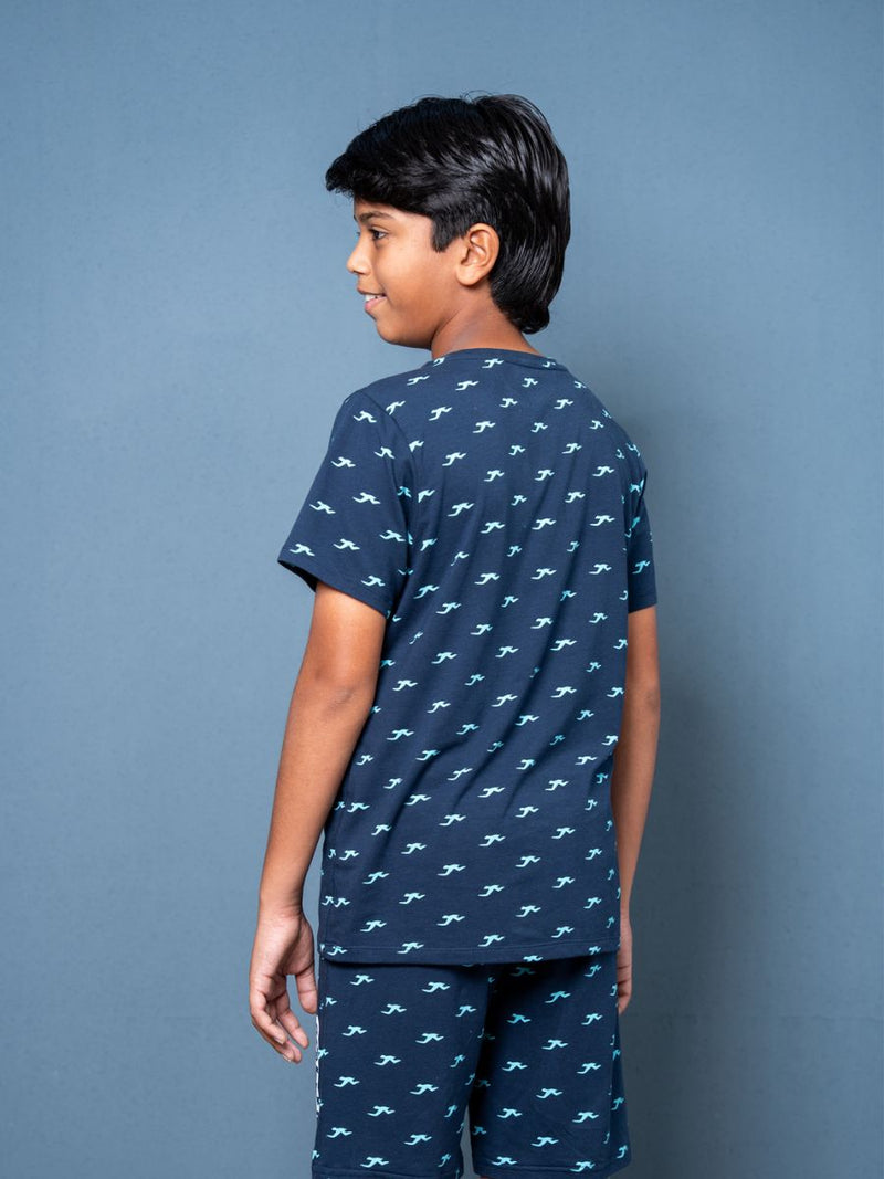 Child wearing a navy blue pajama set with white patterns against a gray background