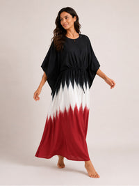 Woman wearing a black, white, and red dress on a plain background