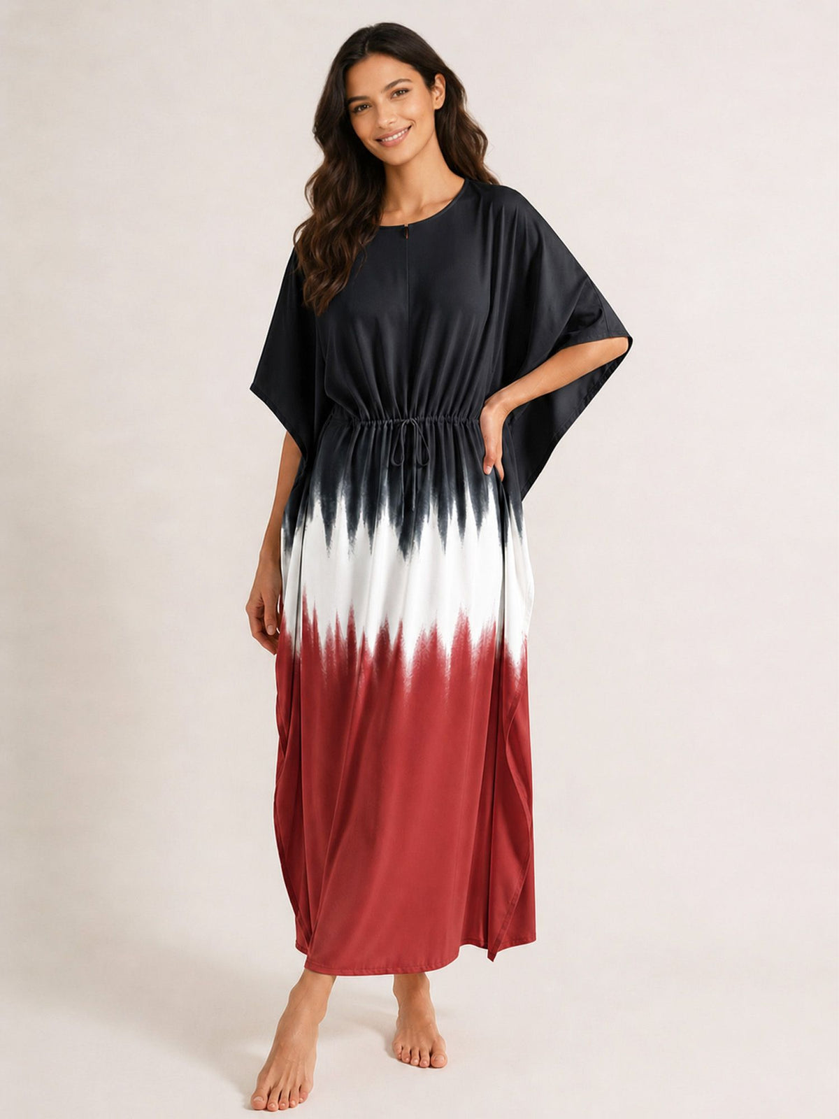Woman wearing a black, white, and red gradient dress on a plain background