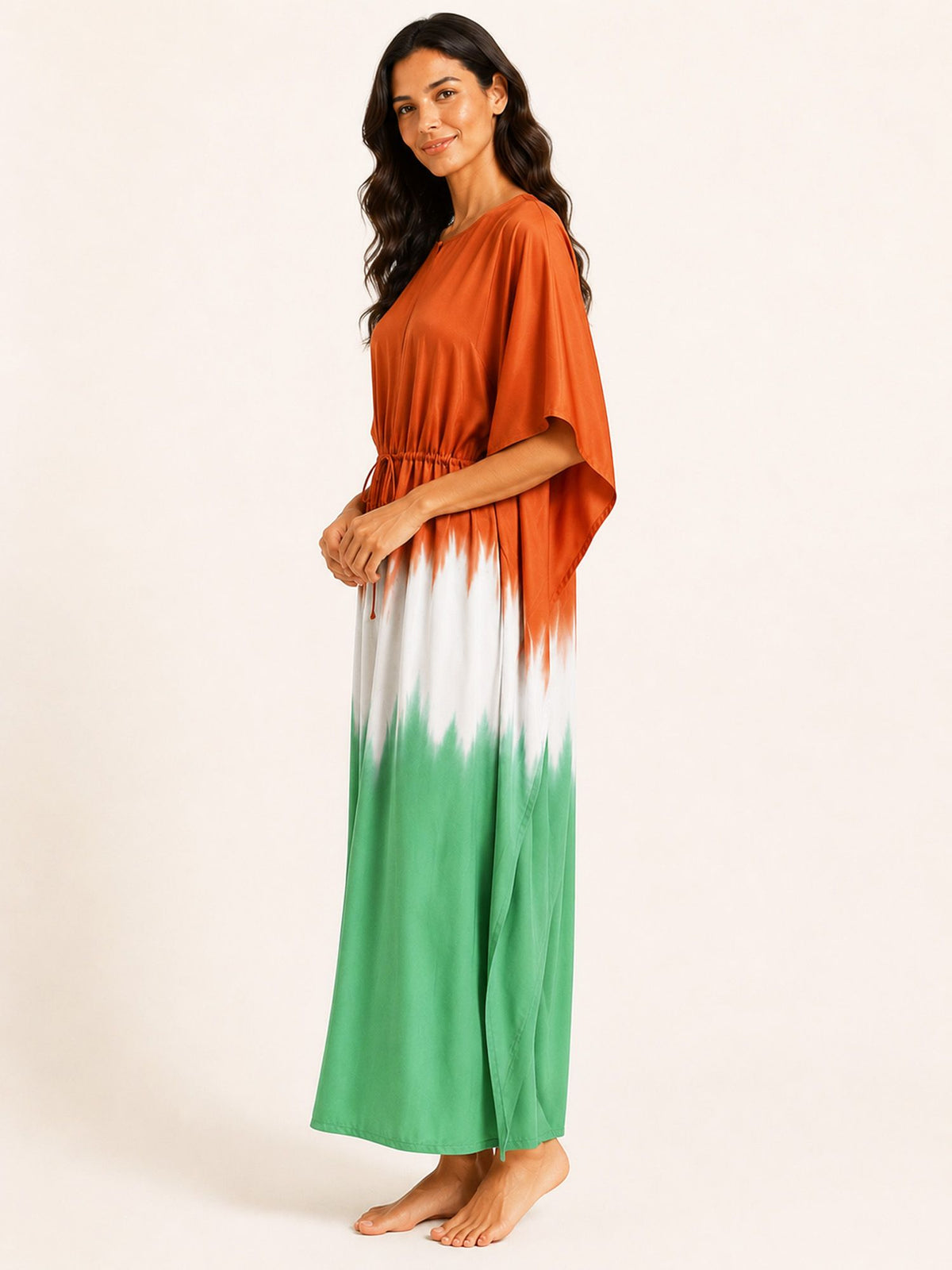 Woman wearing a colorful dress with an orange top and green bottom on a white background