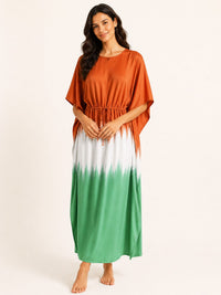 Woman wearing a gradient dress with orange, white, and green colors on a plain background