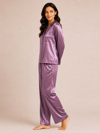 Woman wearing a purple satin pajama set on a beige background