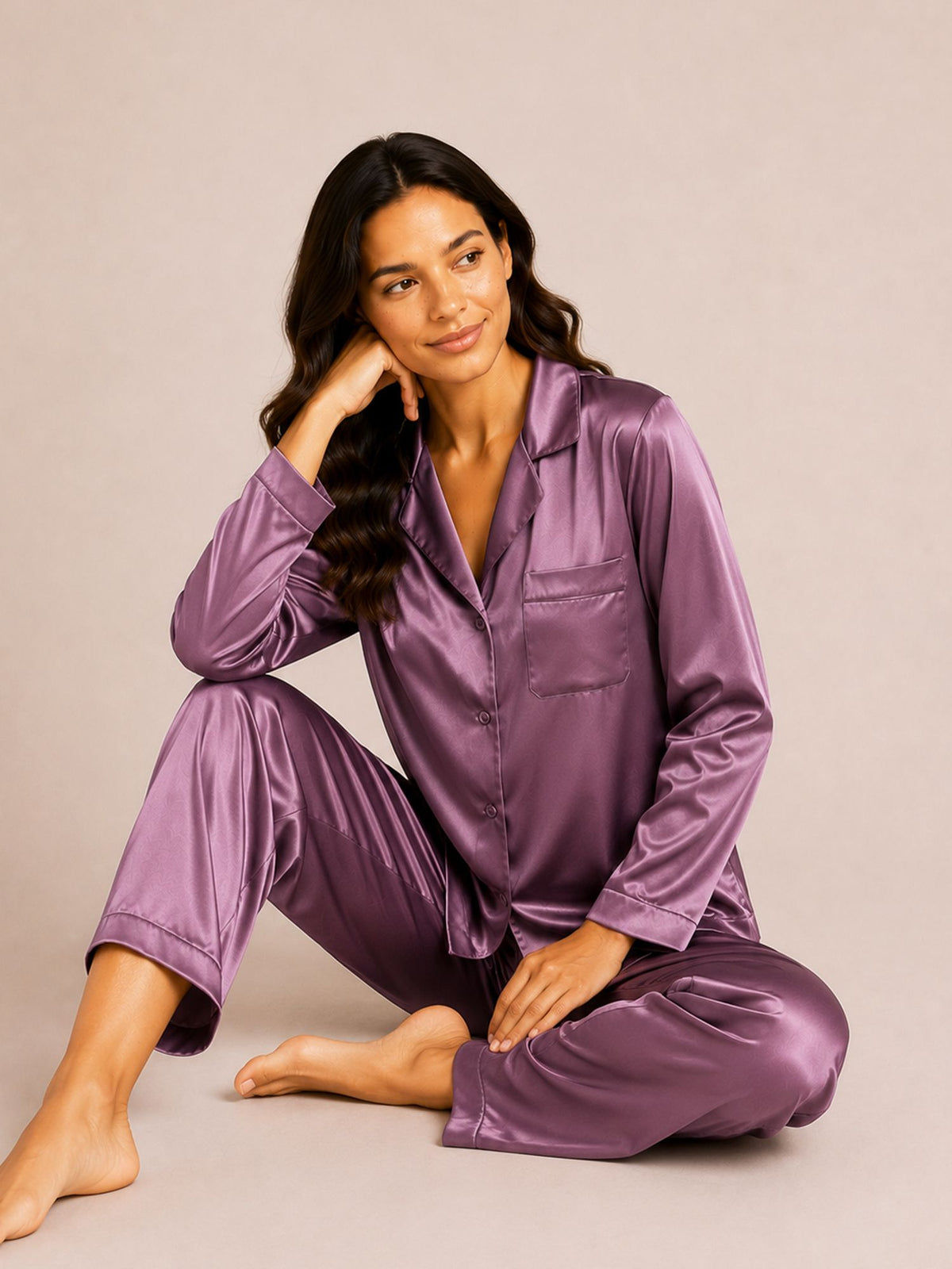 Woman wearing a purple satin pajama set on a beige background