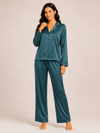 Woman wearing teal satin pajamas on a plain background