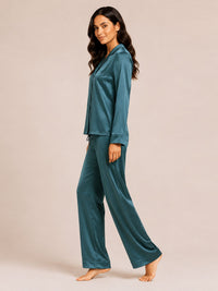 Woman wearing teal satin pajamas on a beige background