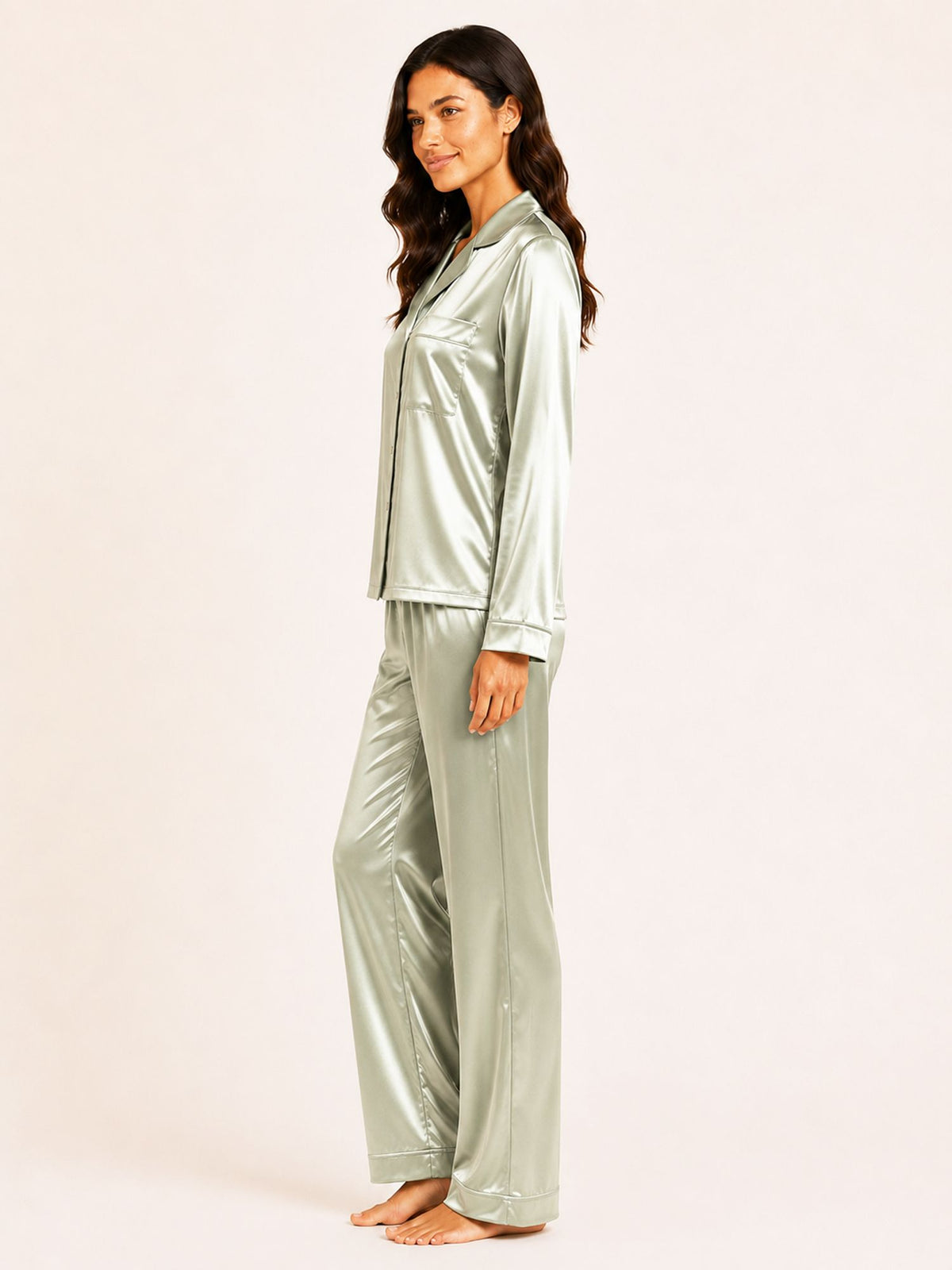 Woman wearing a silver satin pajama set on a white background