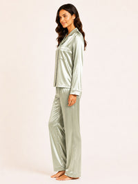 Woman wearing a silver satin pajama set on a white background