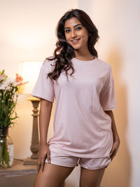 Woman wearing a patterned pajama set in a softly lit room.