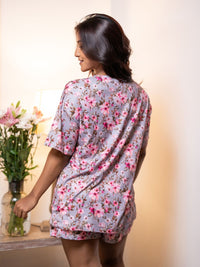 Woman wearing a floral kimono-style robe in a softly lit room.