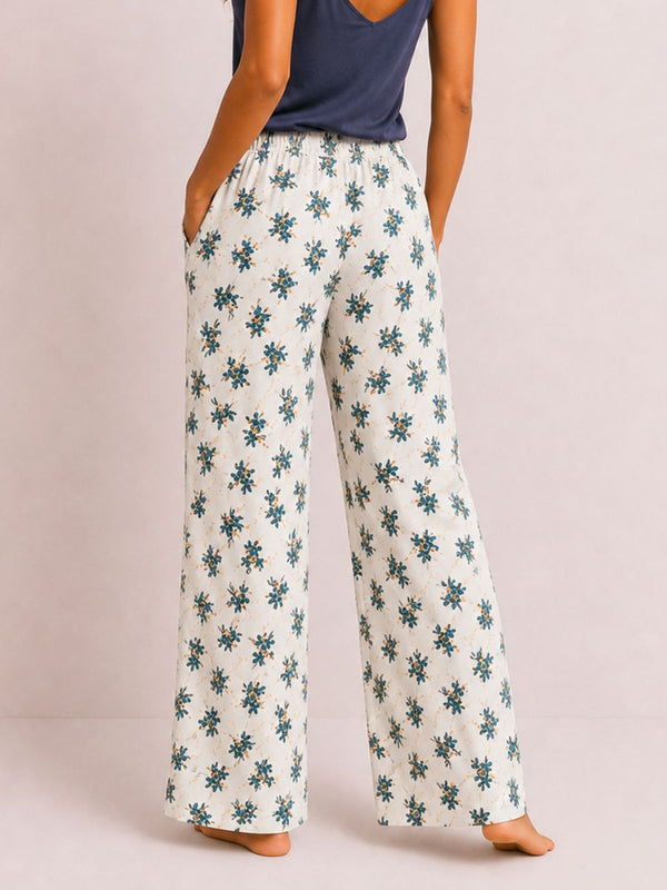 Person wearing floral-patterned pants on a plain background