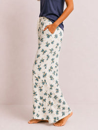 Floral patterned pants worn by a person on a plain background
