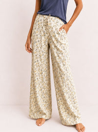 Floral pajama pants worn by a person on a plain background