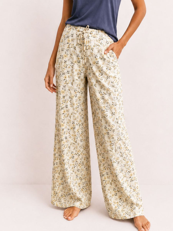Floral pajama pants worn by a person on a plain background