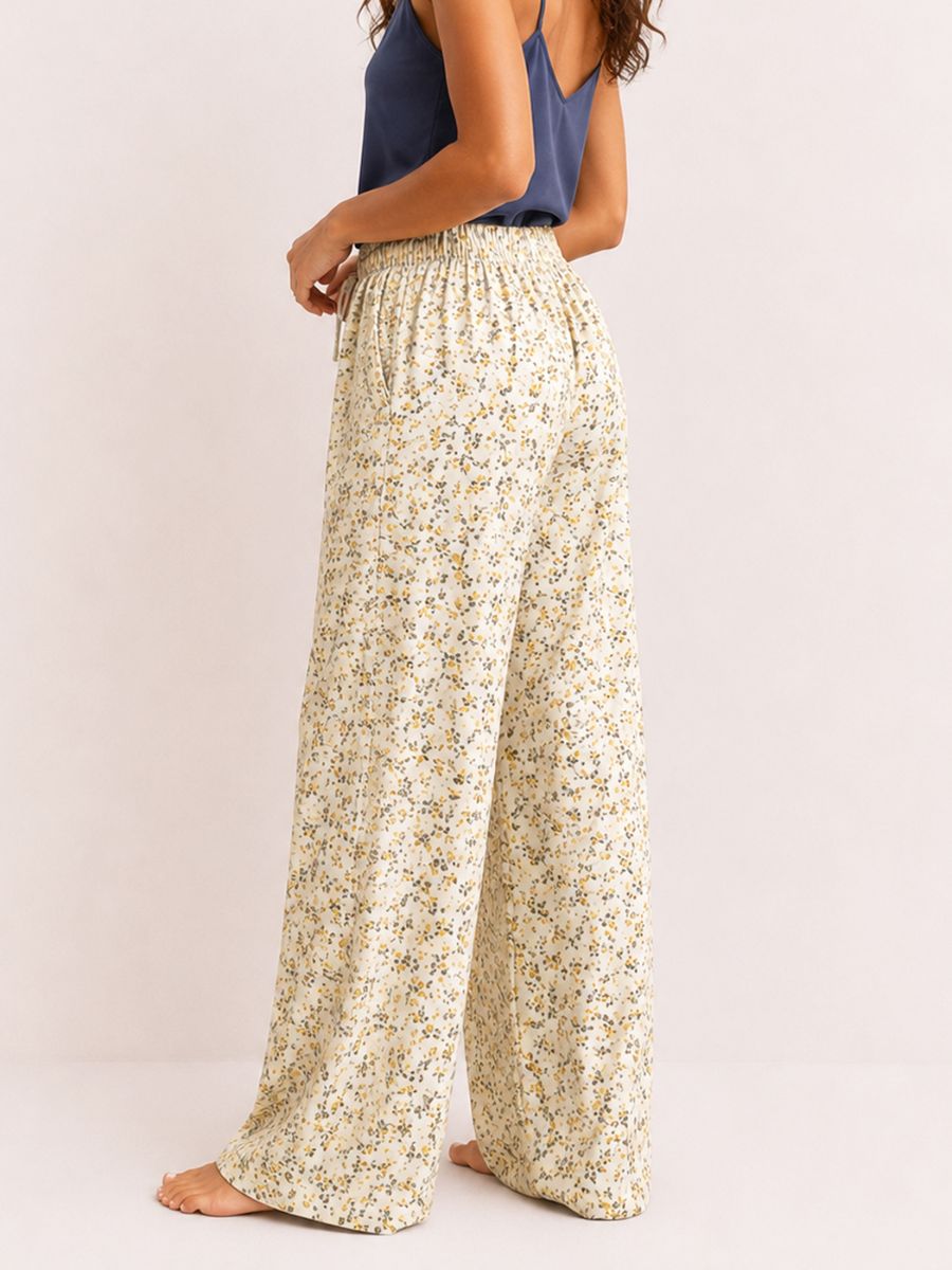 Person wearing floral wide-leg pants on a plain background