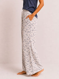 Floral-patterned pajama pants worn by a person on a plain background
