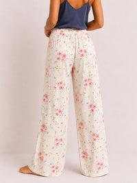 Floral pants worn by a person on a plain background