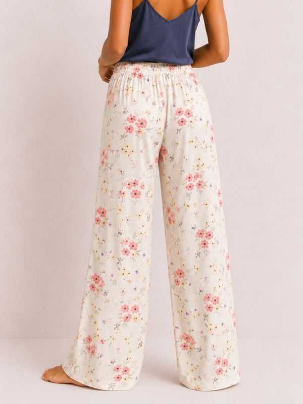 Floral pants worn by a person on a plain background