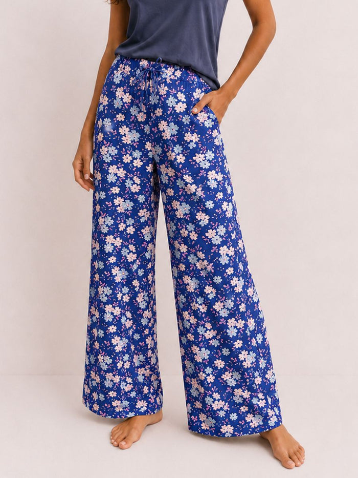 Person wearing blue floral pajama pants on a plain background