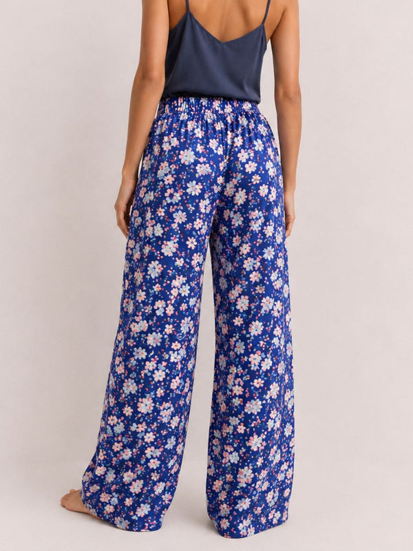 Person wearing blue floral pants on a plain background