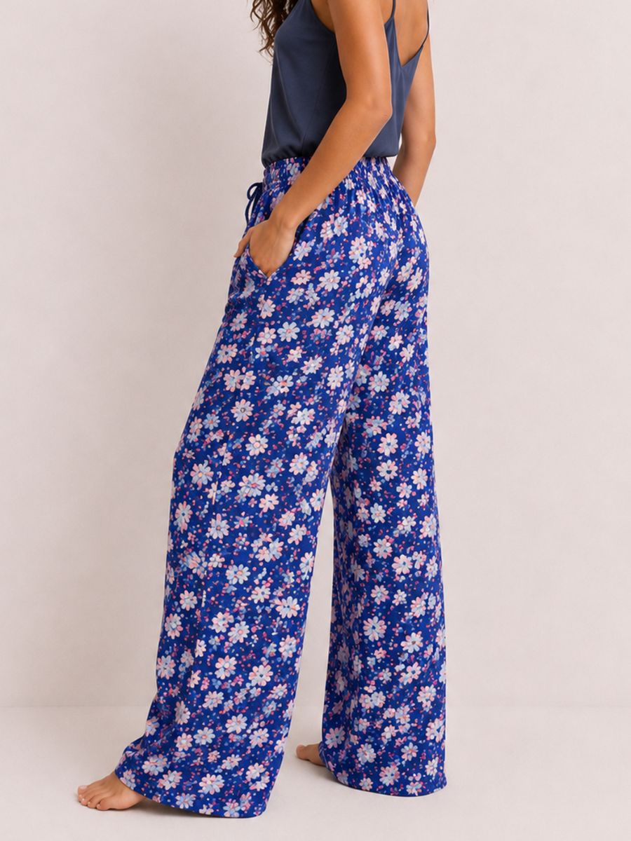 Person wearing blue floral pajama pants on a plain background