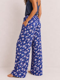 Person wearing blue floral pajama pants on a plain background