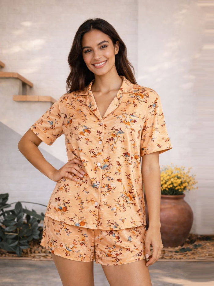 Woman wearing a peach floral pajama set in a home setting.