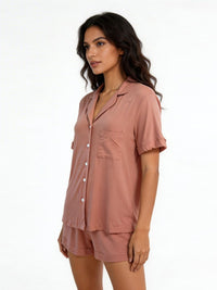 Woman wearing a pink pajama set on a white background