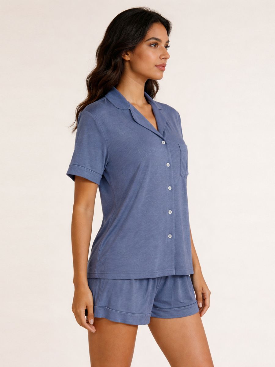 Woman wearing a blue pajama set against a plain background
